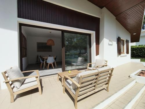 d'une terrasse avec deux chaises, une table et une table. dans l'établissement La maison des rives de Saint Brice, à Arès