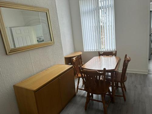 een eetkamer met een tafel en stoelen en een spiegel bij Muram Properties in Kirkby