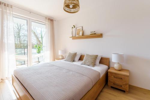 a bedroom with a bed and a large window at CHILLIapartamenty - Wyspa Solna - RIVER in Kołobrzeg