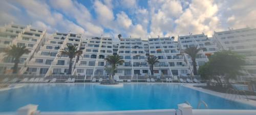 a large apartment building with a large swimming pool at Apartamentos Babalu in Puerto Rico de Gran Canaria