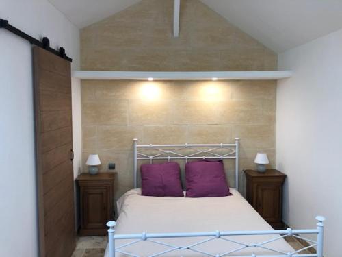 - une chambre avec un lit doté d'oreillers violets dans l'établissement DOMAINE D'ONCE, à Sanguinet