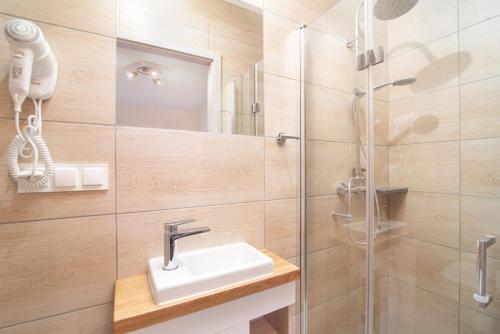 a bathroom with a shower and a sink at Pokoje GENAKER in Jastrzębia Góra
