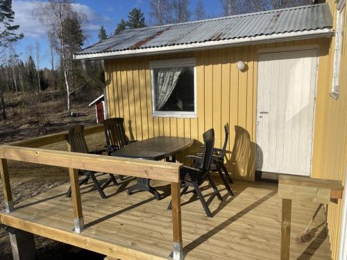 - une terrasse avec une table et des chaises dans une cabine dans l'établissement Berget, à Charlottenberg