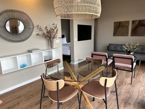 a living room with a glass table and chairs at Urriðafoss Waterfall Lodges in Selfoss