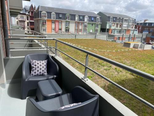 une chaise assise sur un balcon avec un champ dans l'établissement Trimaran Studio 10 mètres de la plage avec balcon/terrasse, à Mers-les-Bains