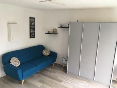 - un canapé bleu dans le salon avec une armoire dans l'établissement Trimaran Studio 10 mètres de la plage avec balcon/terrasse, à Mers-les-Bains
