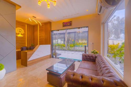 a living room with a leather couch and a glass table at Greenwood Villa By Levelup in Amritsar