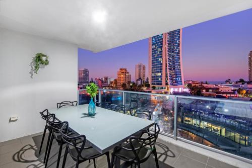 a table and chairs on a balcony with a city skyline at Circle on Cavill Surfers Paradise- 3 Bedroom Superior Apartment in Gold Coast