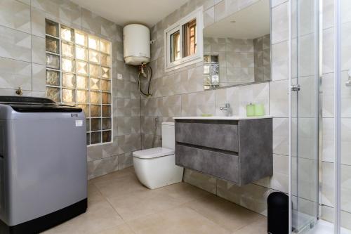 a bathroom with a toilet and a sink and a shower at Newly renovated & cozy apartment in Antananarivo