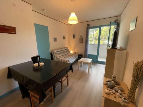 un salon avec une table et un canapé dans l'établissement Appartement cosy 2 pièces à 200m de la plage, Saint-Hilaire-de-Riez - 4 couchages, parking, TV, WiFi - FR-1-224C-294, à Saint-Hilaire-de-Riez