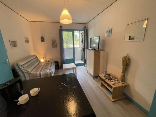 un salon avec un canapé et une table dans l'établissement Appartement cosy 2 pièces à 200m de la plage, Saint-Hilaire-de-Riez - 4 couchages, parking, TV, WiFi - FR-1-224C-294, à Saint-Hilaire-de-Riez