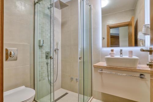 a bathroom with a shower and a toilet and a sink at Symphony Apartments Street View in Petrovac na Moru