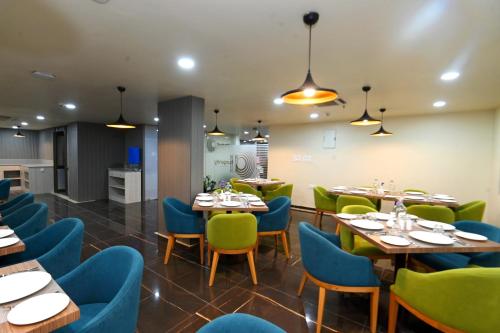 um restaurante com mesas e cadeiras e uma cozinha em Regenta Inn Bannerghatta Bangalore em Bangalore