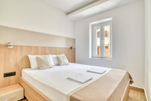 a bedroom with a large white bed with a window at Symphony Apartments Street View in Petrovac na Moru