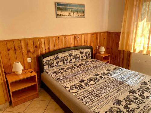 Un dormitorio con una cama con una manta. en An-Ta Nyaraló Fonyód, en Fonyód