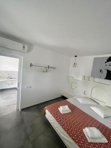 a white room with a bed with a red blanket at Sonia in Mikonos
