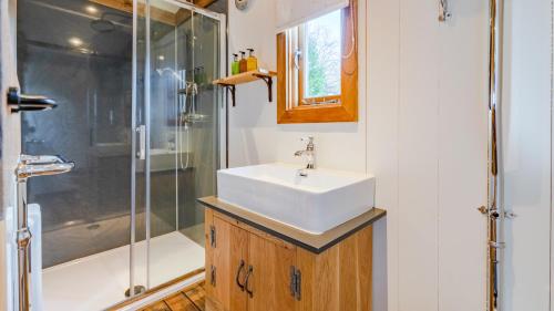 a bathroom with a sink and a shower at Betty Shepherd's Hut in Lydney