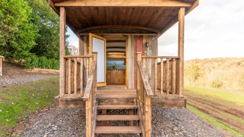 a tiny house with a staircase leading to the door at Betty Shepherd's Hut in Lydney
