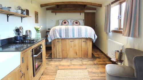 a small kitchen with a bed in a room at Betty Shepherd's Hut in Lydney