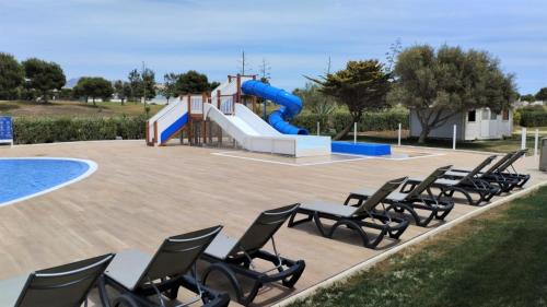 a group of chairs and a playground with a slide at Ohtels Cabogata in Retamar