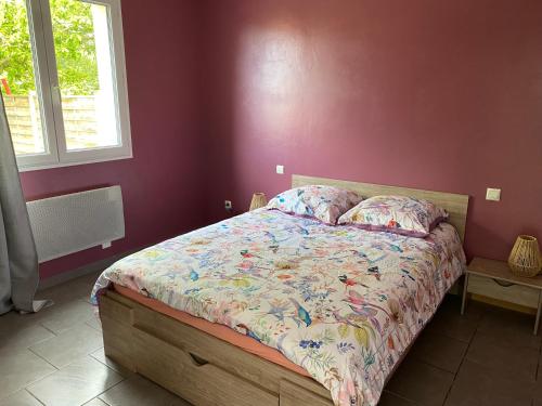 sypialnia z łóżkiem w czerwonej ścianie w obiekcie L'estran w mieście Marennes