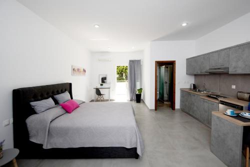 a bedroom with a large bed with a pink pillow at Maria Studios & Apartments in Kremasti