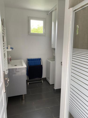 une petite salle de bain avec un lavabo et une chaise dans l'établissement L'estran, à Marennes