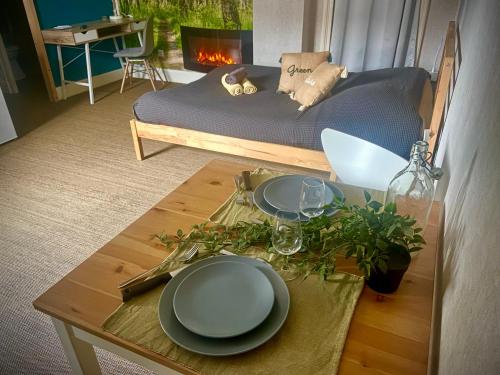 uma mesa com pratos e copos e uma cama num quarto em Studio Nature, proche du centre-ville em Dijon