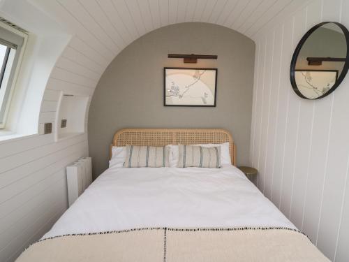 a small bedroom with a bed with white sheets at Ceunant in Aberystwyth