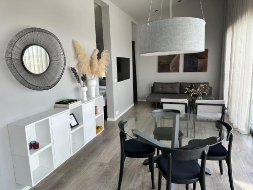 a dining room with a glass table and chairs at Urriðafoss Waterfall Lodges in Selfoss