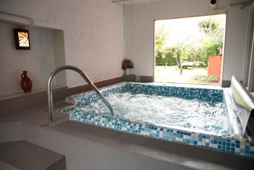 eine Whirlpool-Badewanne in einem Zimmer mit Fenster in der Unterkunft Casa de Piñeiro y SPA (opcional) in Santiago de Compostela