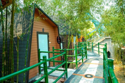 a small building with a green fence around it at MEDDOM Park in Cao Phong