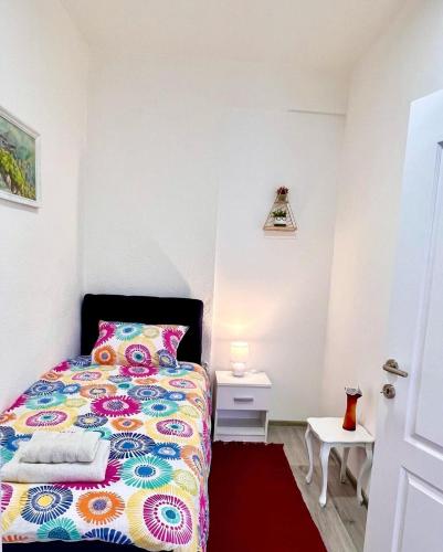 a bedroom with a bed with a colorful bedspread at M Apartman in Foča
