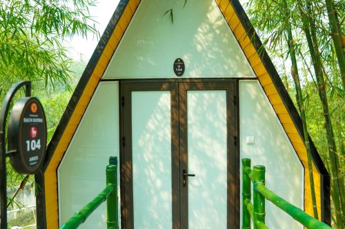 a building with a glass door in a forest at MEDDOM Park in Cao Phong