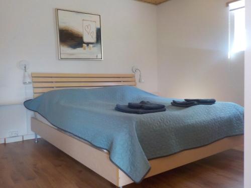 Un dormitorio con una cama con una manta azul. en Lyngsasgaard M, en Saeby
