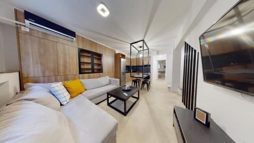 a living room with a white couch and a table at The Gate by Zoia Living in Athens