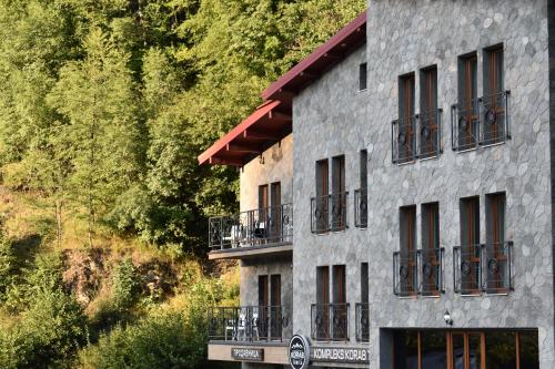 Hotel Korab Trnica في Trnica: مبنى فيه بلكونات على جانب جبل