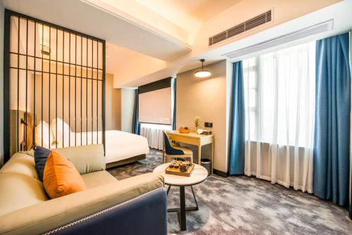 una camera d'albergo con divano e tavolo di Sky Hotel - Shenzhen Luohu Sungang BaoNeng Center a Shenzhen