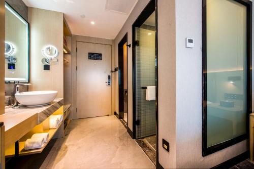 W łazience znajduje się umywalka i lustro. w obiekcie Sky Hotel - Shenzhen Luohu Sungang BaoNeng Center w mieście Shenzhen