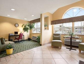 a large lobby with chairs and a desk in a building at Days Inn & Suites by Wyndham Lafayette IN in Lafayette
