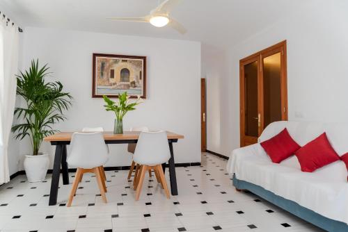 Apartamento Antonio - Puerto Pollensa في بورت دي بوينسا: غرفة نوم بسرير وطاولة وكراسي