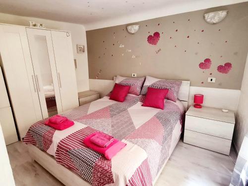 um quarto com 2 camas com almofadas cor-de-rosa em Sweet Home Appartamento 4 posti letto 10 min dal mare em Badalucco