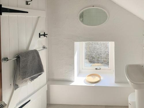 łazienka z umywalką, toaletą i oknem w obiekcie Grain End w mieście Sawdon
