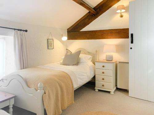 a bedroom with a white bed and a white dresser at Grain End in Sawdon