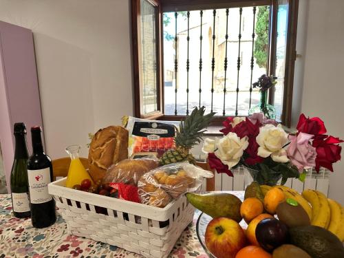 un tavolo con un cesto di frutta e una bottiglia di vino di Al hilo de Landaluce a Laguardia