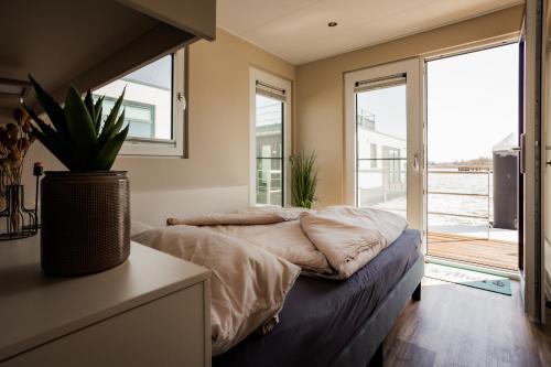 Un dormitorio con una cama y una ventana grande. en Hausboot Küstennebel, en Ribnitz-Damgarten
