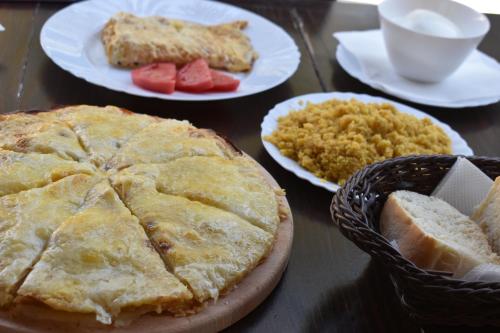 a table topped with plates of food with bread and fruit at Hotel Korab Trnica in Trnica