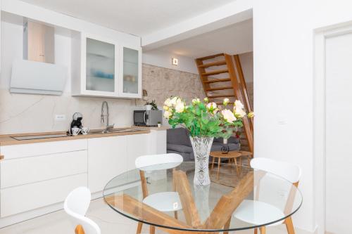 Apartment Meri في سوتيفان: مطبخ وغرفة طعام مع طاولة وكراسي زجاجية