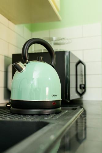 a tea kettle sitting on top of a stove at Newly renovated & cozy apartment in Antananarivo