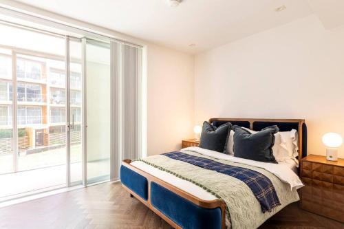 ロンドンにあるLuxury 2 bedroom Flatのベッドルーム1室(ベッド1台、大きな窓付)